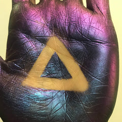 Hand applying multichrome eyeshadow with fingertip, showing vibrant color shift on eyelid