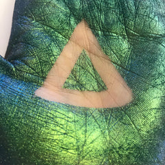 Green textured material with triangle shape, shown on skin