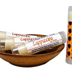 Lip balm tubes with white labels and red text, in a brown bowl, and a patterned tube