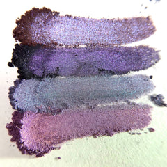 Eyeshadow swatches in purple, silver, and brown with shimmer on white background