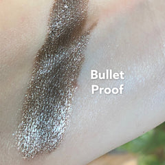 Eyeshadow swatch in metallic brown with glitter on skin, "Bullet Proof" text visible