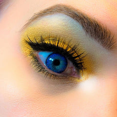 Blue eye with gold eyeshadow and black eyelashes, close-up view of eye makeup