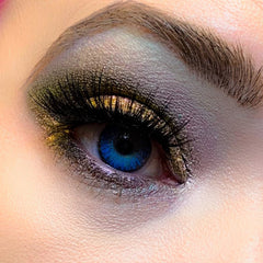 Eye makeup with blue eye, gold and purple eyeshadow, and black eyelashes