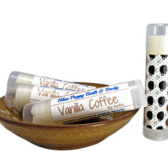 Lip balm tubes with white labels, brown text, and coffee cup pattern, Blue Poppy Bath & Body brand visible