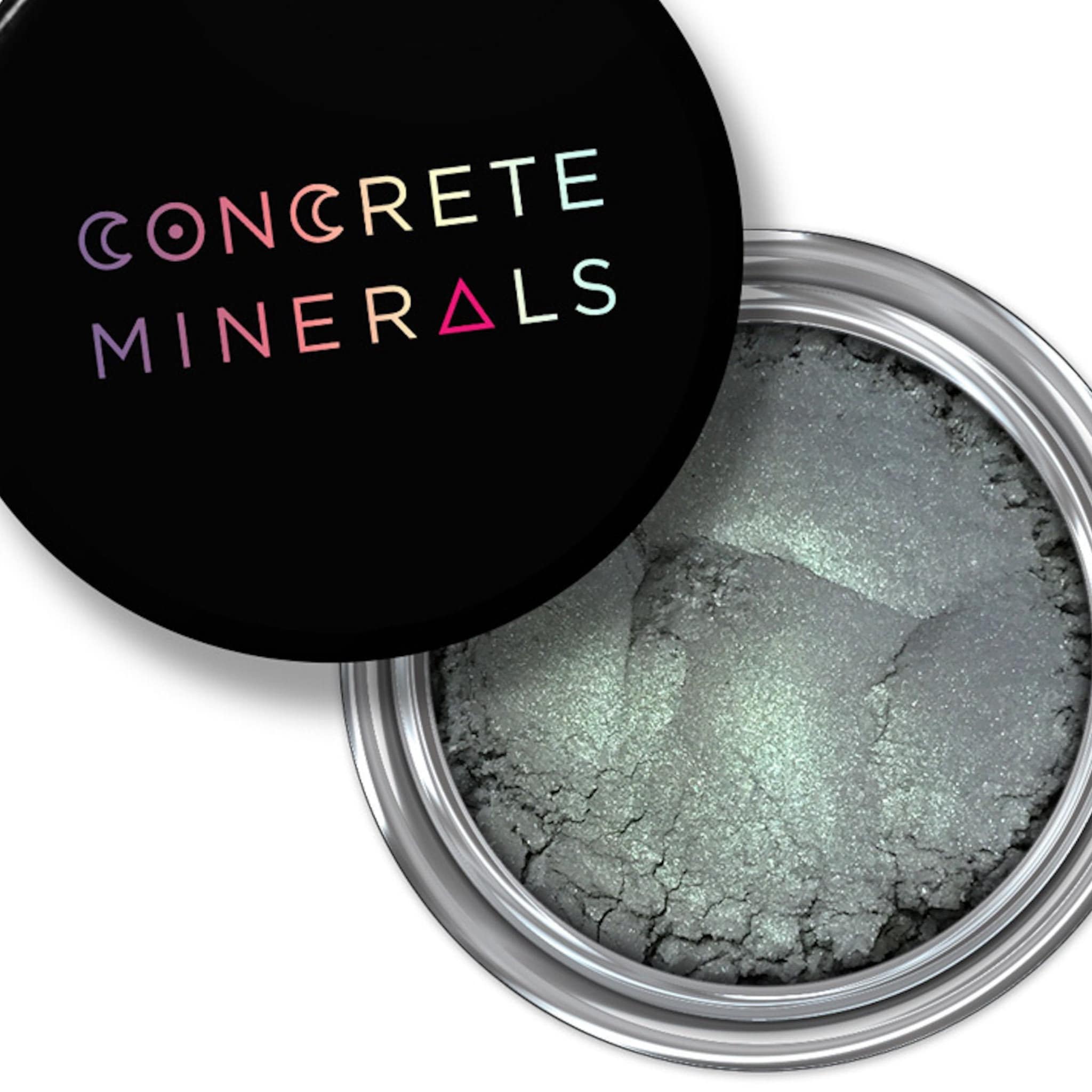 Vegan eyeshadow, metallic green powder, black lid with Concrete Minerals text, silver container