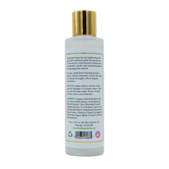 Facial cleanser bottle with gold cap, white label, and brand text visible on packaging
