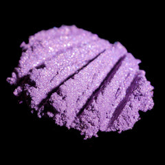 Purple eyeshadow powder with glitter and textured surface on black background