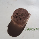 Eye shadow dark brown powder in clear jar with Zookeeper text visible