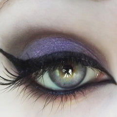 Eye makeup with purple eyeshadow, black eyeliner, and long eyelashes, close-up view