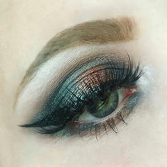 Makeup eye shadow with teal, brown, and black colors, used for eye makeup application