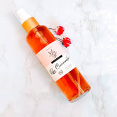 Rose face toner bottle, orange liquid, white and pink label, Nizzy Naturals branding