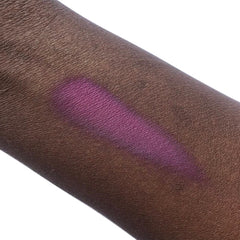 Purple eyeshadow swatch on dark skin, showing color and texture