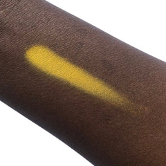 Yellow eyeshadow swatch on dark skin, showing color and texture