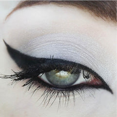 Eyeliner application with black wing and grey eyeshadow on eye with long lashes