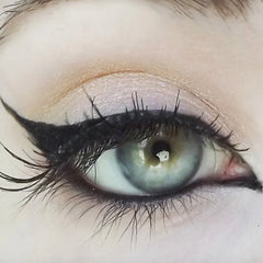 Eye makeup with black eyeliner, long eyelashes, and blue-green iris