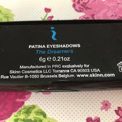 Eyeshadow box with black background, white text, and Skinn Cosmetics brand name visible