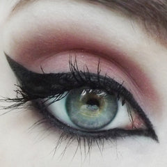 Eyeliner makeup with black wing, pink eyeshadow, and green eye with long lashes