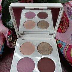 Eyeshadow palette with white case, four colors, and mirror reflection