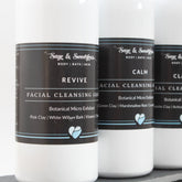 Facial cleansing grains in white bottles with black labels, Revive product name