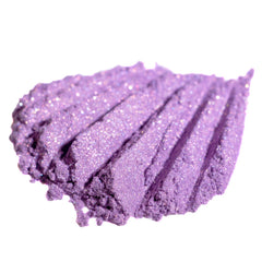 Purple eyeshadow swatch with glitter and textured finish on white background