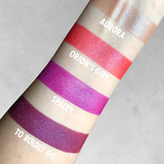 Hand applying shimmering taupe mineral eyeshadow with a fluffy brush for a soft, blended look