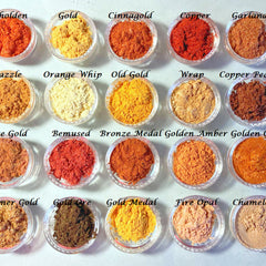 Close-up of shimmering gold, bronze, and copper eye shadows with pink quartz minerals in circular pans