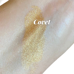 Swatched gold shimmer with "Covet" text on skin, showing color and texture