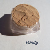 Eyeshadow pigment in sandy matte brown, in clear plastic jar, Vanity brand visible