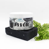 Skin care mask jar with white lid, black charcoal block, and green leaf detail