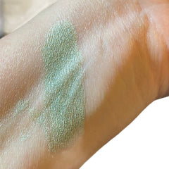 Eyeshadow swatch, green shimmer, applied on skin, close-up view