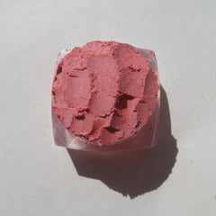 Close-up of loose Sunset Orange eyeshadow pigment with shimmer particles, showcasing vibrant color and fine texture.