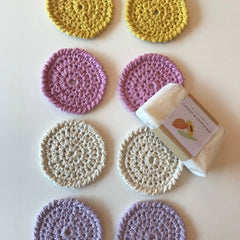 Crochet washcloths in yellow, pink, beige, and purple with a bar of soap, handmade style