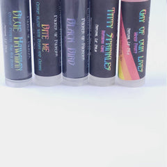 Lip balm tubes with black, holographic text and white base, various flavors visible