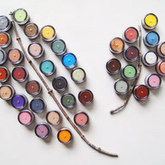 Side view of vintage lace mineral eye shadow compact showing textured lid and soft pink powder