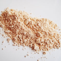 Close-up of soft beige mineral eye shadow with subtle shimmer in vintage lace-inspired compact