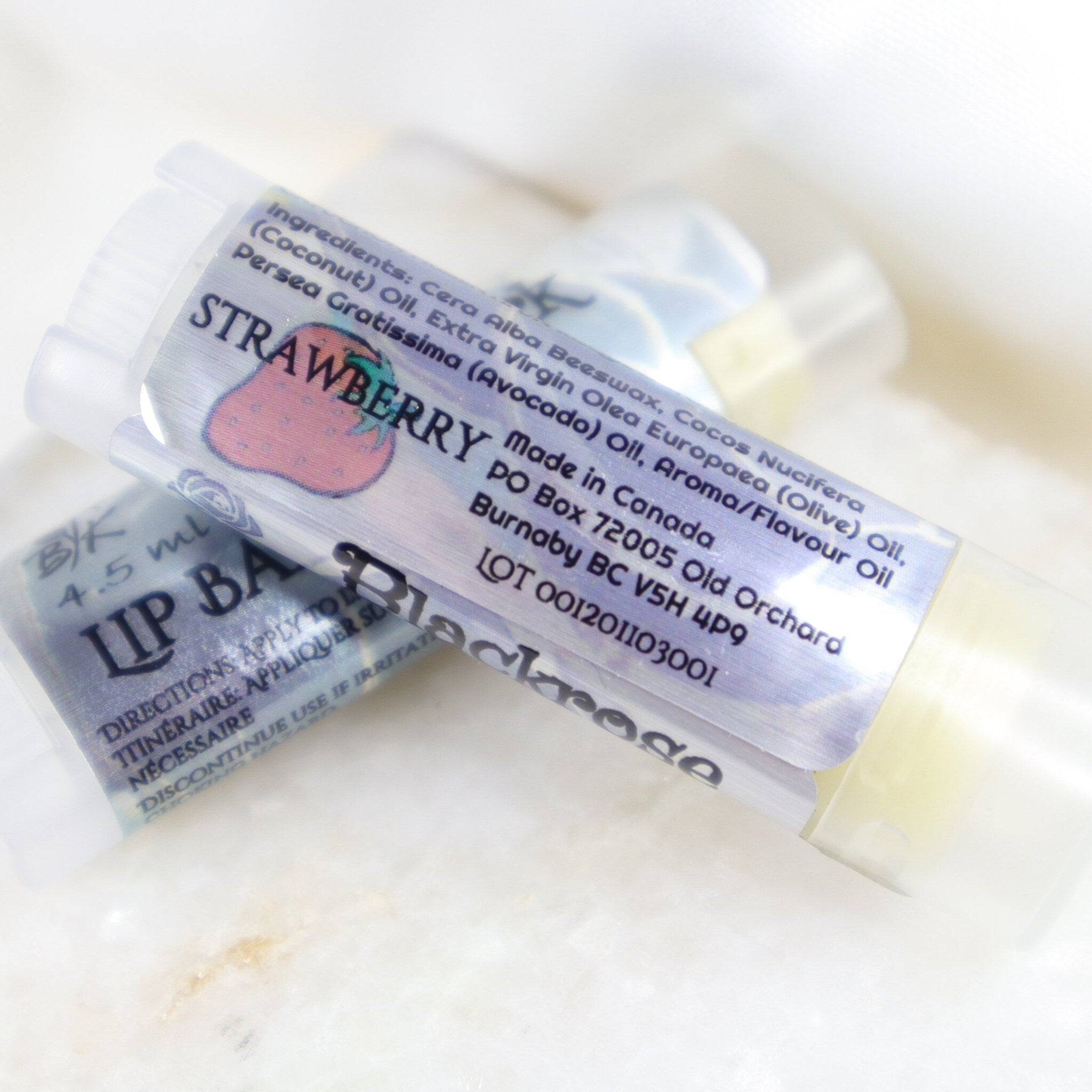 Lip balm tubes with strawberry label, clear plastic, and BlackroseKraftwork branding