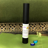 Mascara black tube with Alev Cosmetics label on green fabric and decorative gold trim