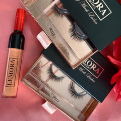 Mink lashes in black with gold packaging and LEMORA cosmetics bottle with red top