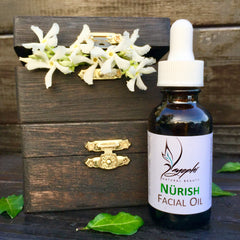 Golden facial oil being gently pressed into glowing skin with fingertips, showcasing radiant application