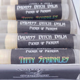 Lip balm tubes with black labels, white text, and clear plastic, Badass Apothecary brand