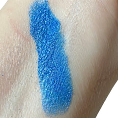 Blue eyeshadow swatch on skin, showing metallic texture and color