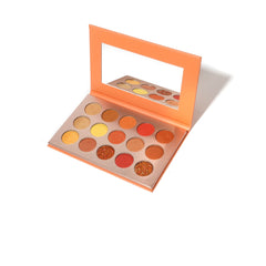 Side view of shimmering eye shadow palette showcasing gradient shades from champagne to deep bronze