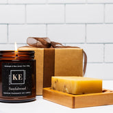 Bath & body gift set with brown candle, gift box, and soap on wooden tray