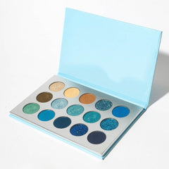 Close-up of a makeup brush applying shimmering taupe eye shadow to eyelid crease