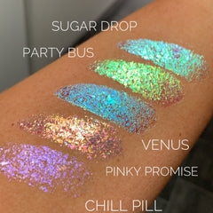 Side view of multichrome eye shadow flakes in iridescent packaging, showcasing shifting hues from purple to green