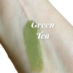 Close-up of matte green tea eyeshadow pan showing smooth, pigmented powder texture in earthy green hue