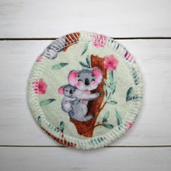Reusable makeup remover pad with koala print, floral pattern, and white stitched edge