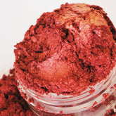 Eyeshadow, red shimmer powder in clear jar, close-up view