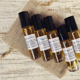 Eye serum bottles with black caps and amber liquid on burlap sack, A Wild Apothecary