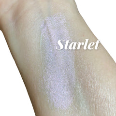 Swatched highlighter with iridescent shimmer on skin, "Starlet" text overlayed